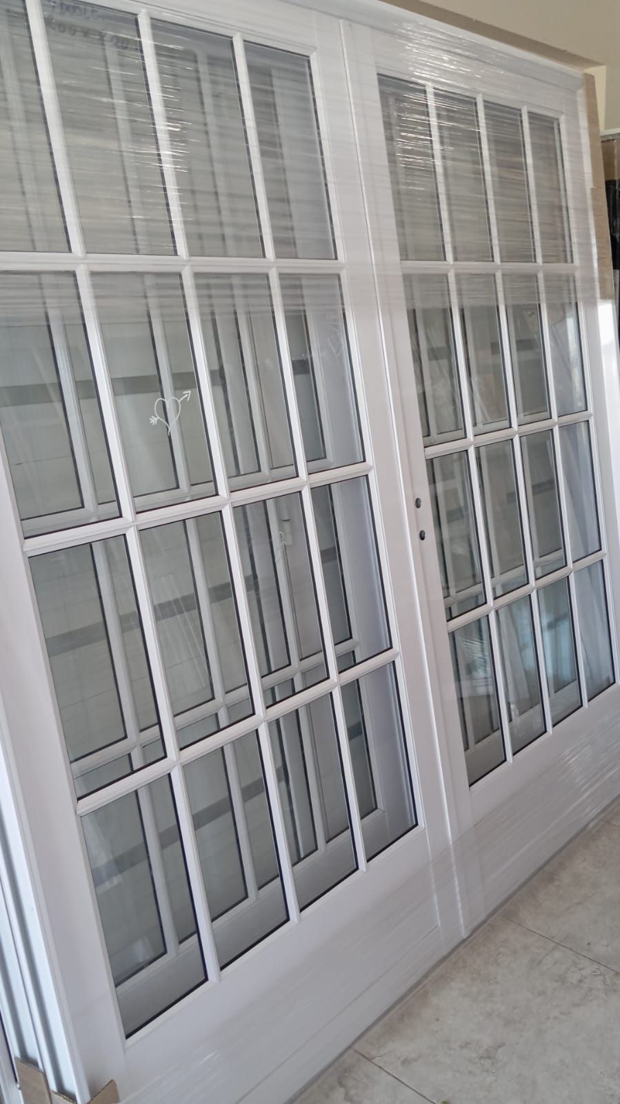 Puertas francesas blancas con múltiples paneles de vidrio.