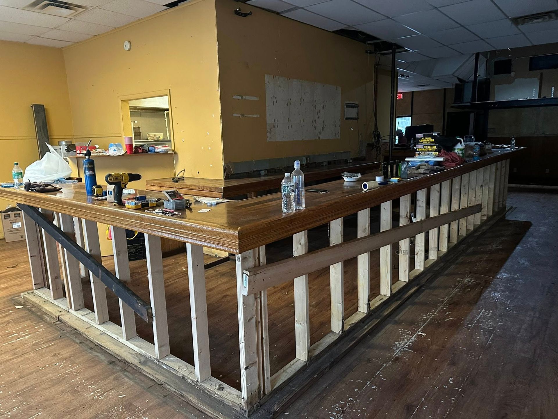 Construction site, bar. Wooden bar frame with a finished countertop, tools and supplies on top.
