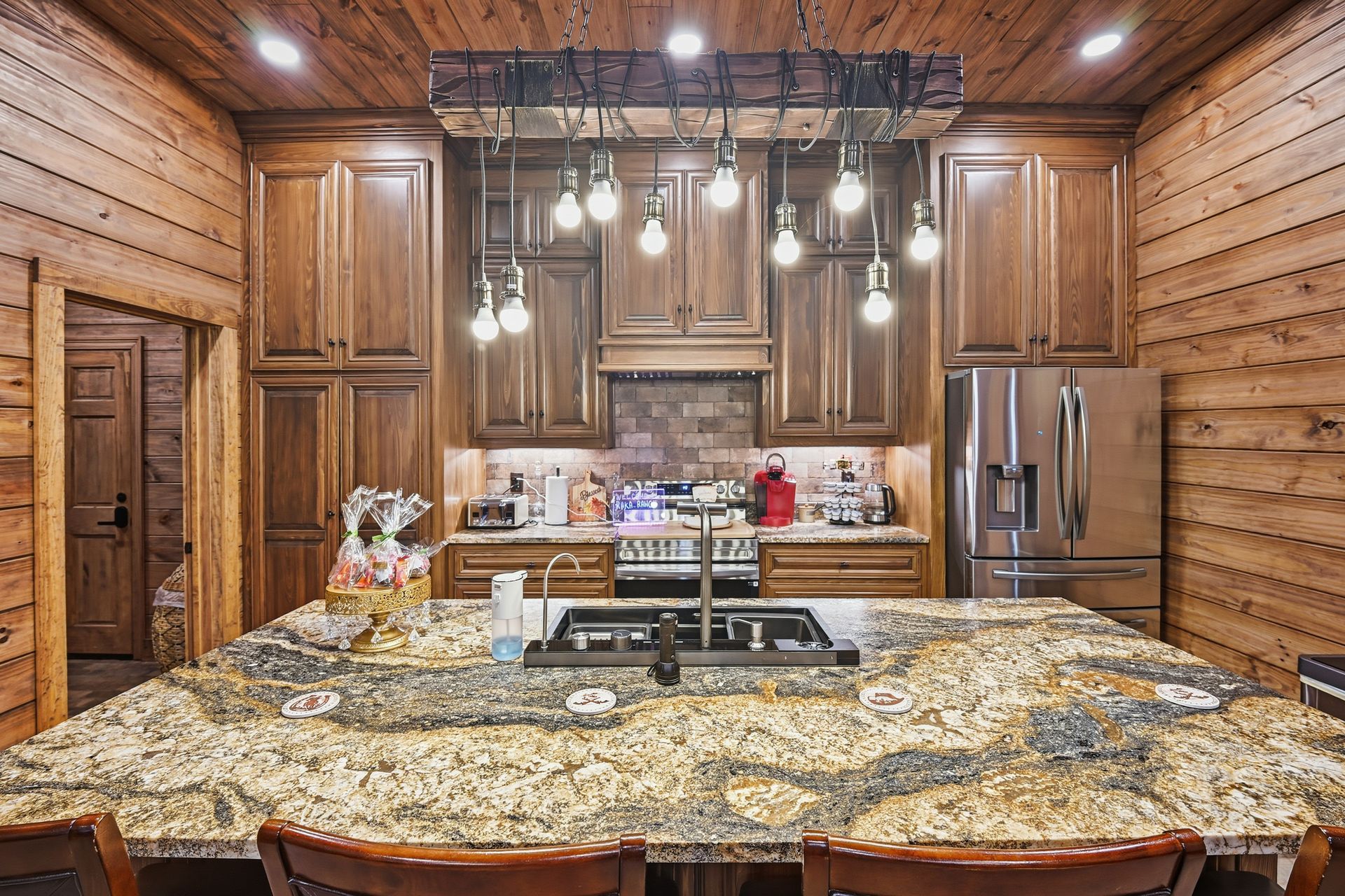 A rustic kitchen with wood-paneled walls, dark wood cabinets