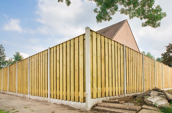 a wooden fence is surrounding a house with steps leading to it .