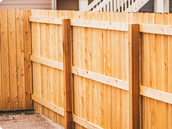 a wooden fence with a gate in the backyard of a house .