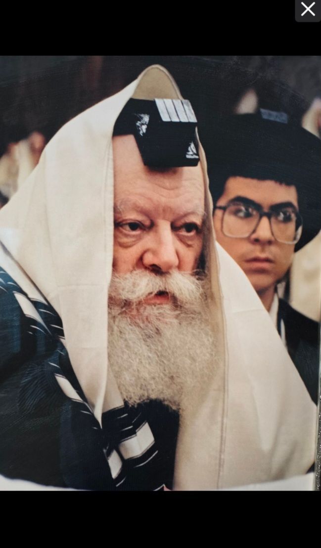 A man with a beard is wearing a black hat and glasses