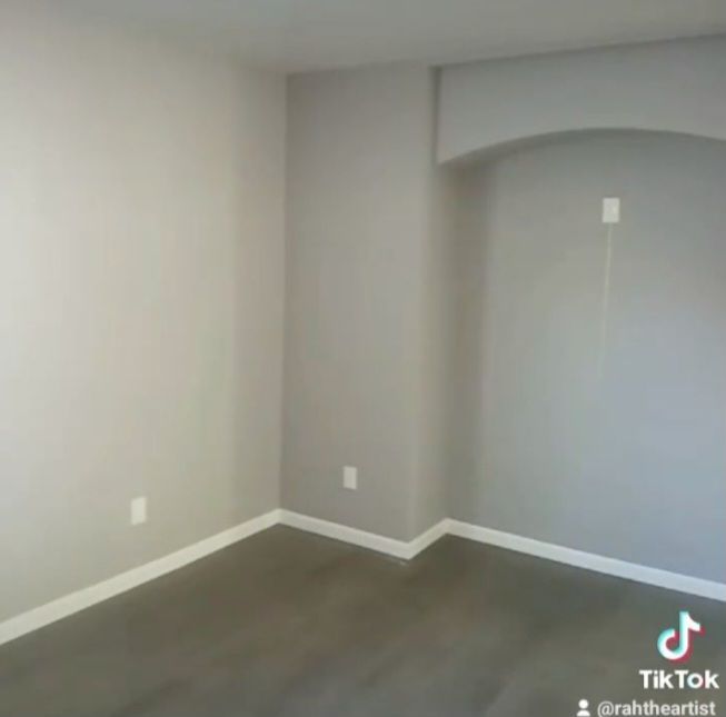An empty room with gray walls and white trim