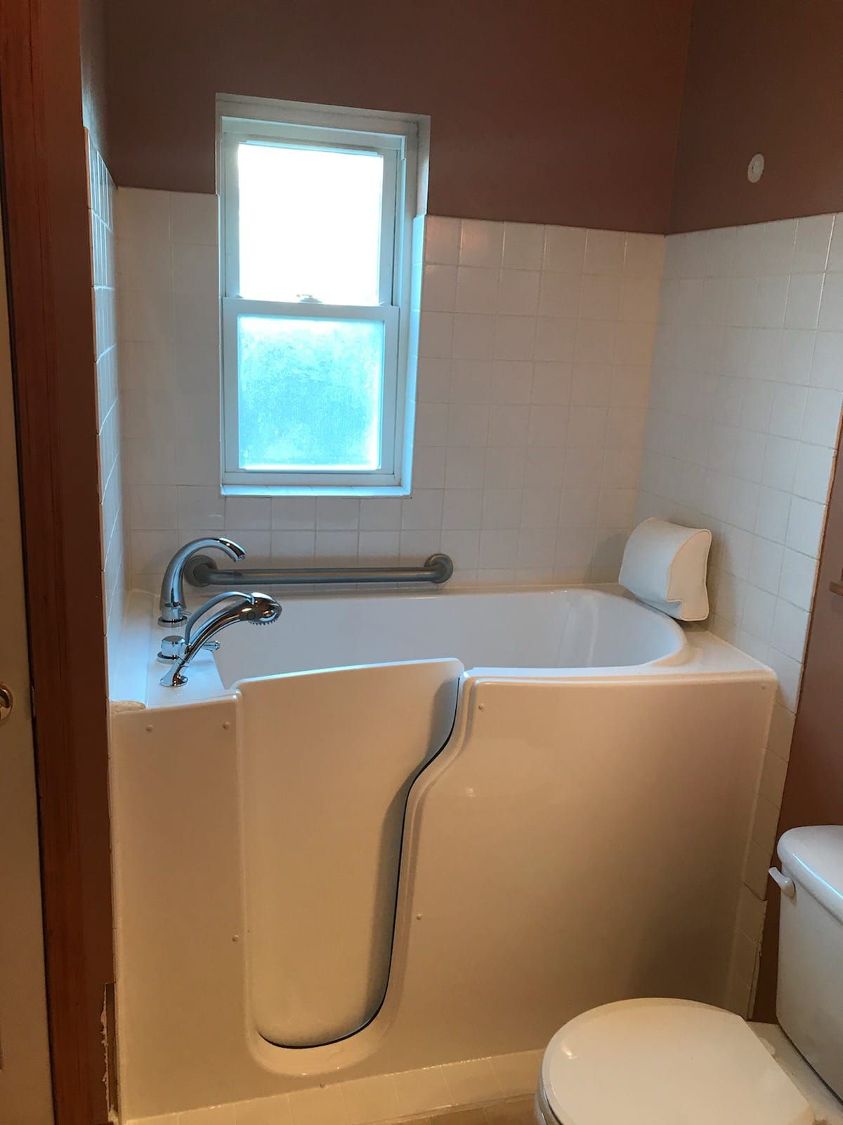 A bathroom with a walk in tub and a toilet.