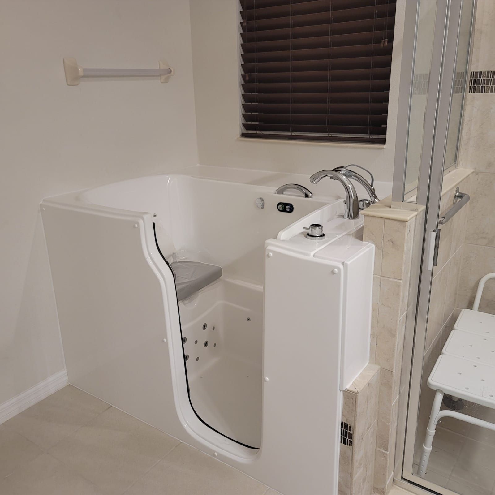 A walk in tub with a door open in a bathroom.