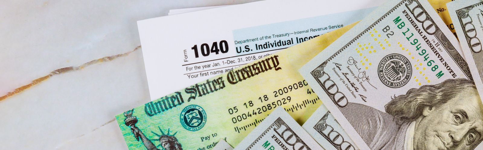 image of US currency, government check, and IRS 1040 tax form