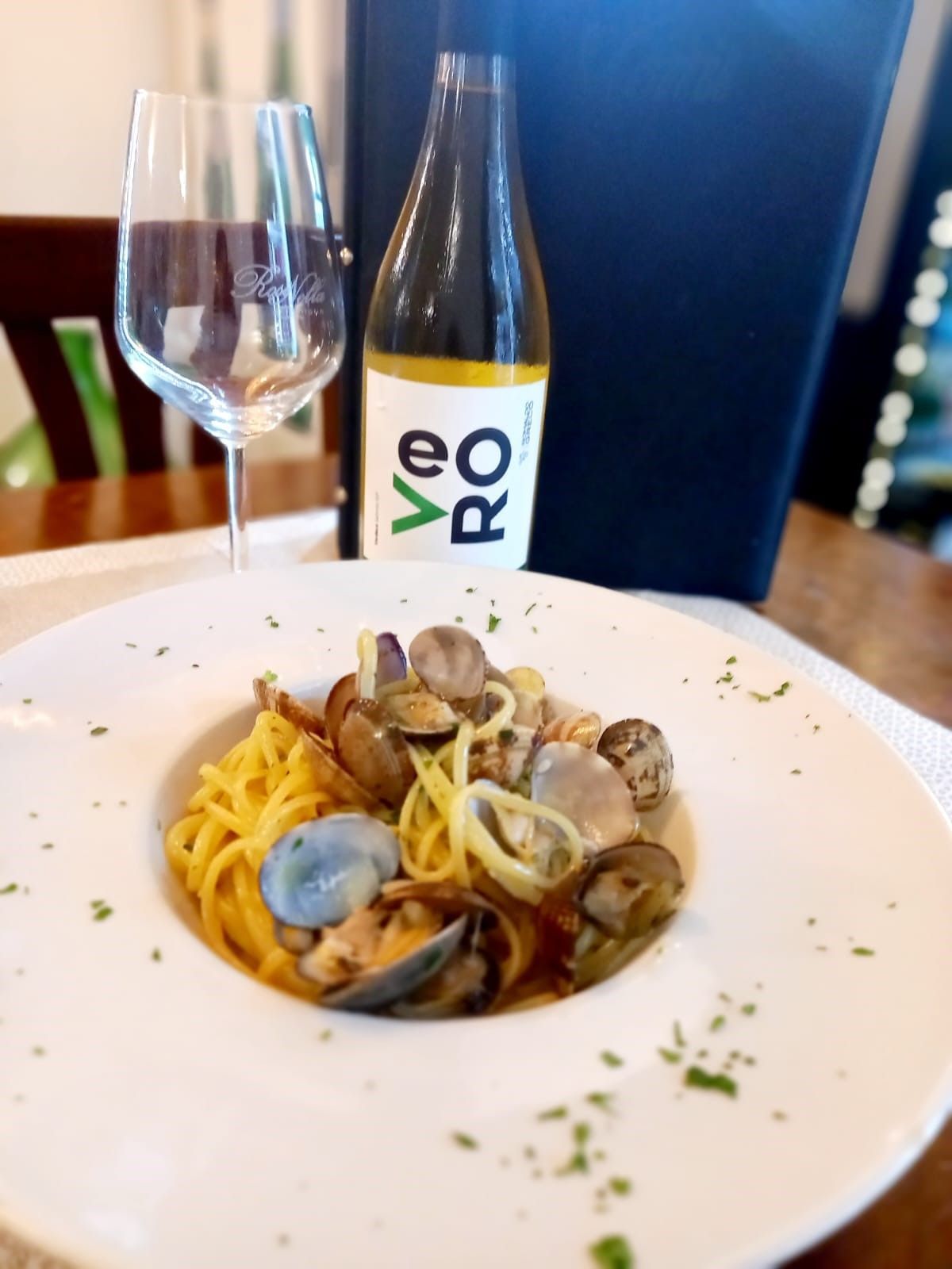 Una bottiglia di vino Veo è appoggiata accanto a un piatto di cibo