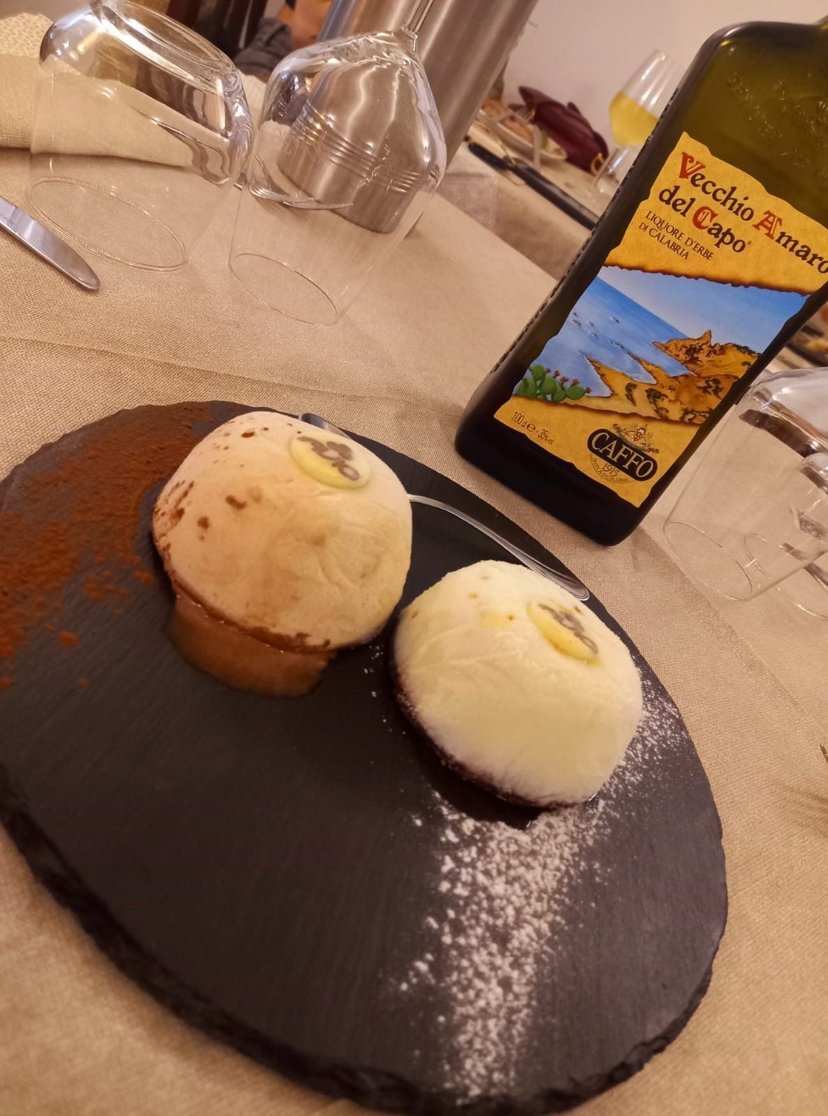 Una bottiglia di Vecchio Rosano del Capo è appoggiata su un tavolo accanto a un piatto di cibo