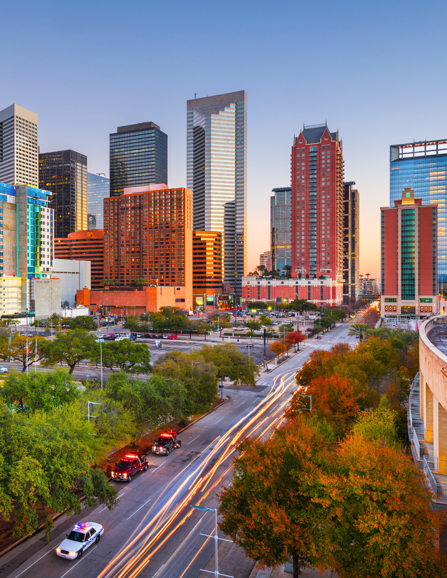 Houston skyline in the fall with orange and yellow trees along a river — perfect seasonal backdrop f