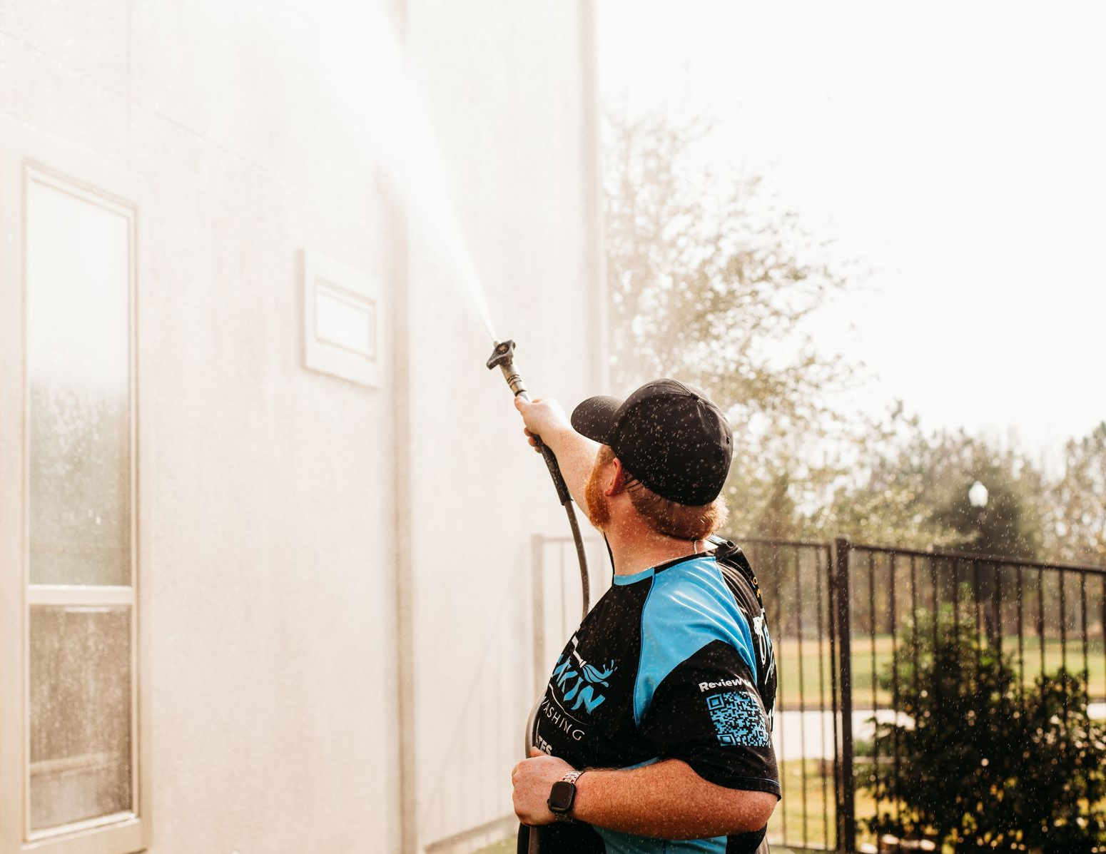 Power washing the exterior of a Houston-area home during a spring house wash service