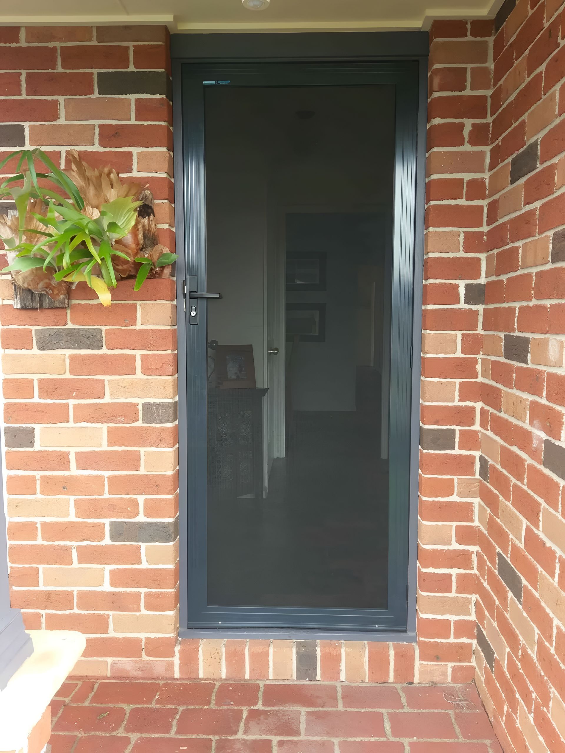 Screen Door in Gray Frame Set in Brick Wall — LeSands Screens & Blinds Moss Vale Pty Ltd in Moss Vale, NSW