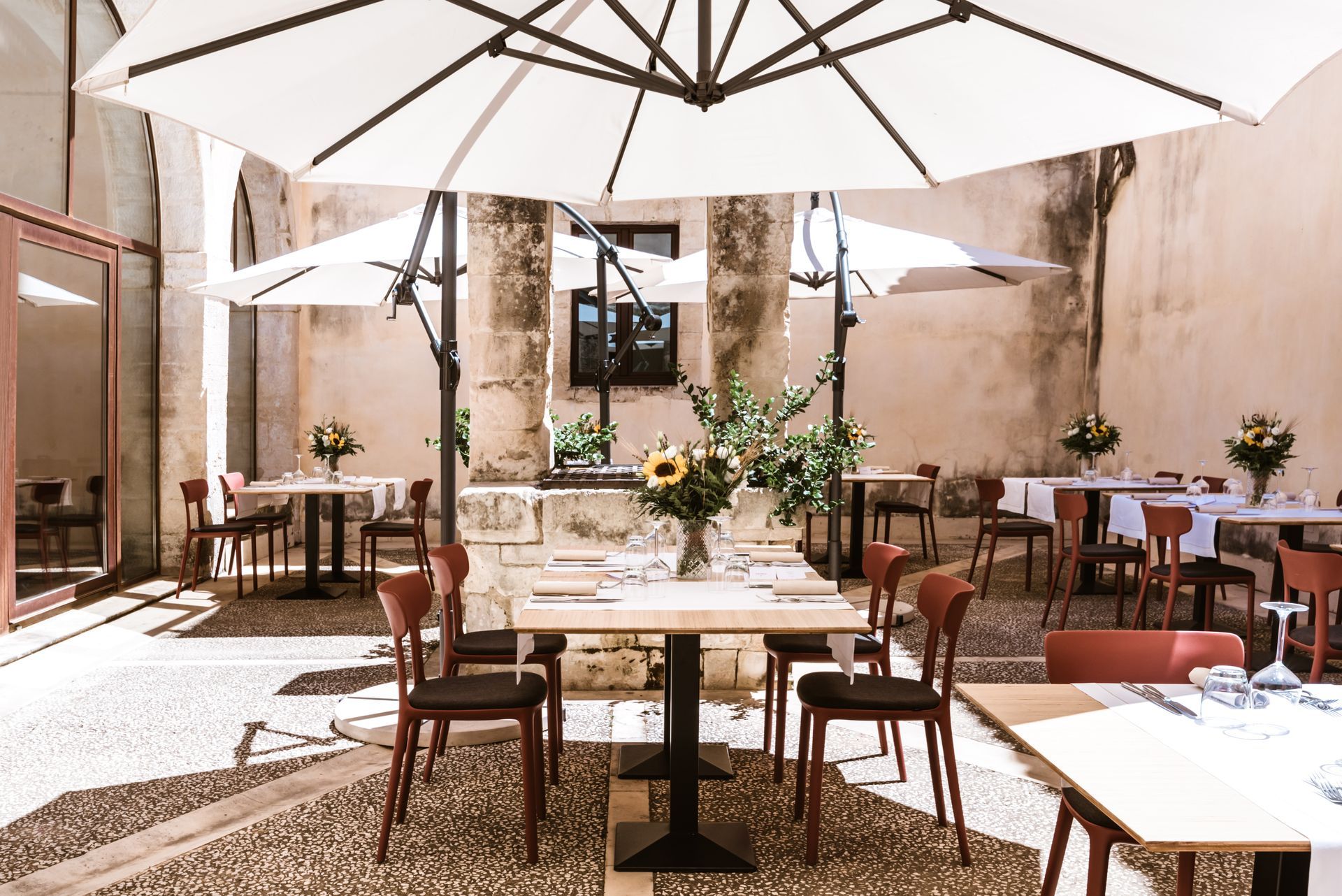 Un ristorante con tavoli e sedie sotto gli ombrelloni | Antico Convento dei Cappuccini | Ragusa Ibla | Sicilia