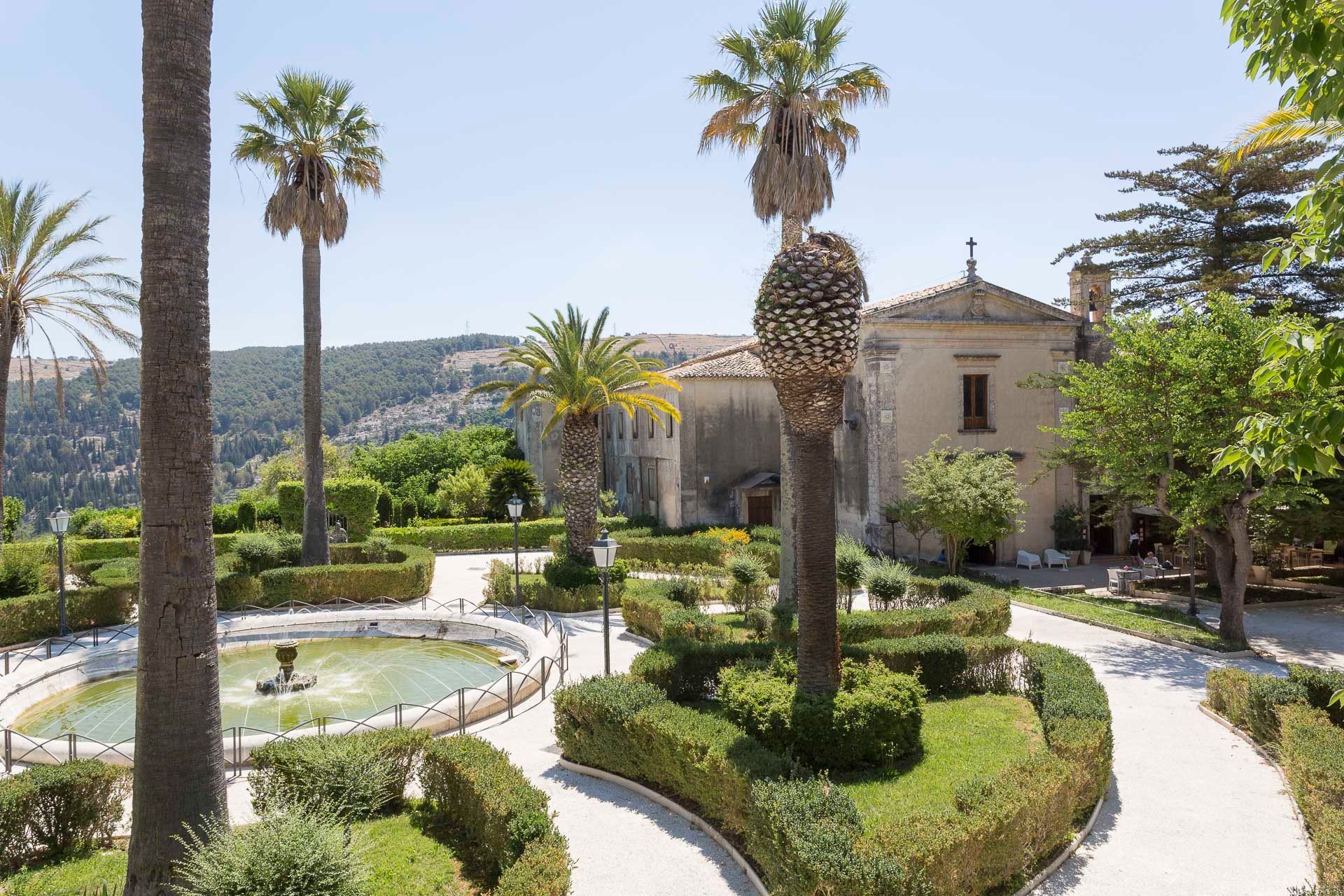 C'è una fontana al centro dei giardini circondata da palme  | Antico Convento dei Cappuccini | Ragusa Ibla | Sicilia