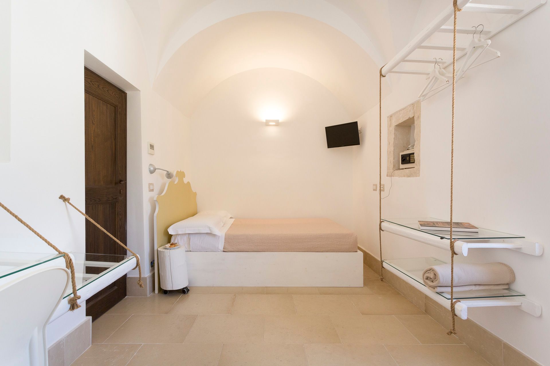 Una camera con un letto e un tavolo in vetro. Hotel Ritiro con Vista | Antico Convento dei Cappuccini | Ragusa Ibla | Sicilia