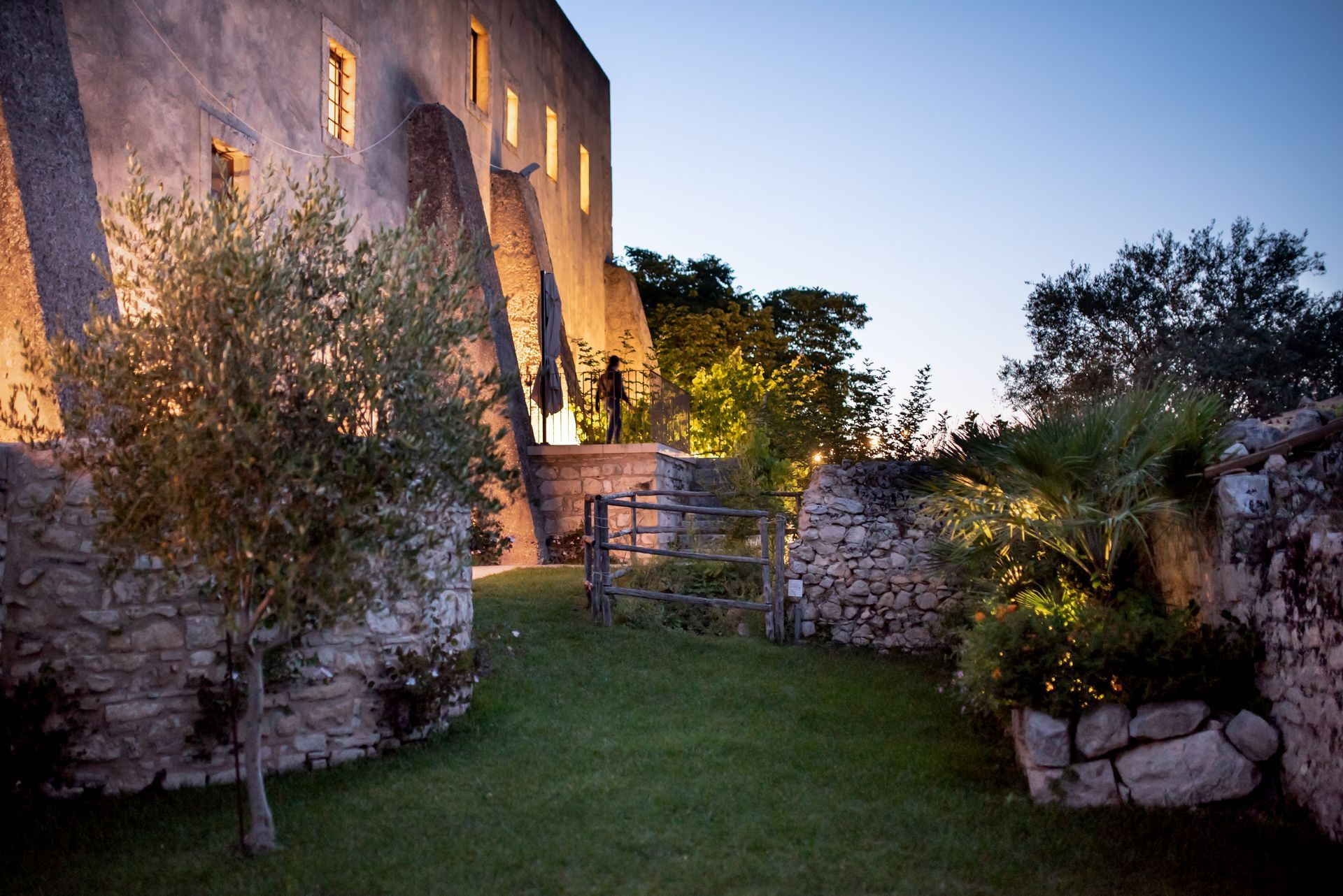 Un muro di pietra circonda un rigoglioso prato davanti ad un edificio. eventi privati all'antico Convento dei Cappuccini