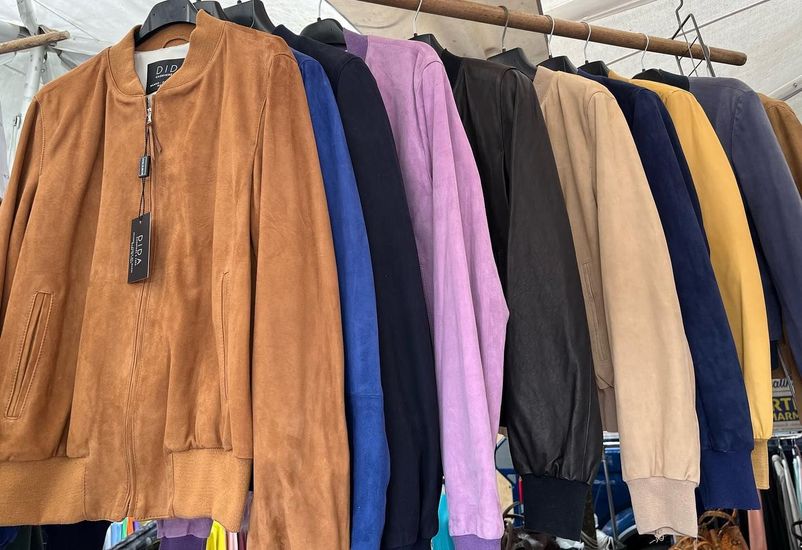 Una fila di giacche è appesa su uno scaffale in un negozio.