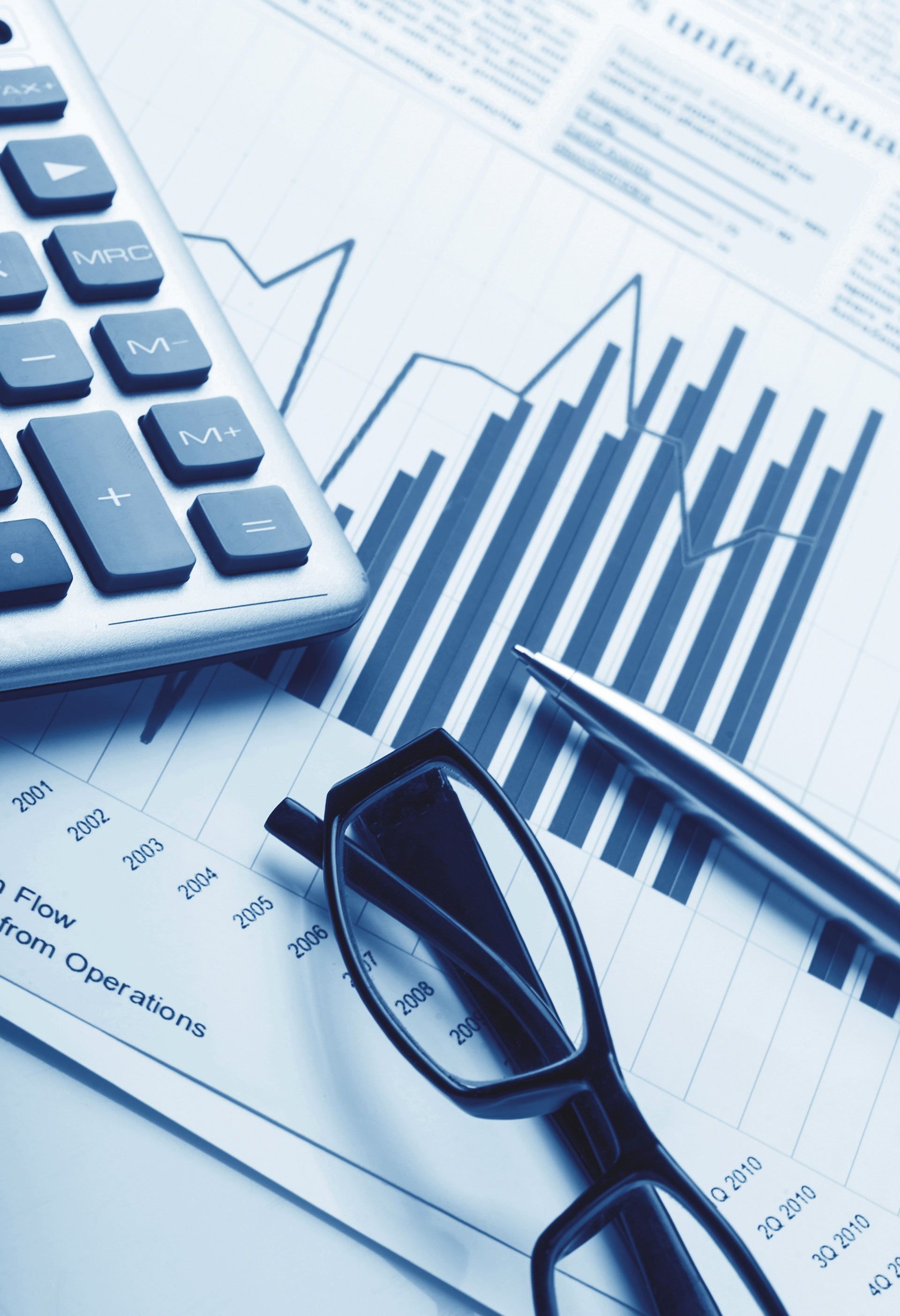 A pair of glasses a pen and a calculator on top of a graph