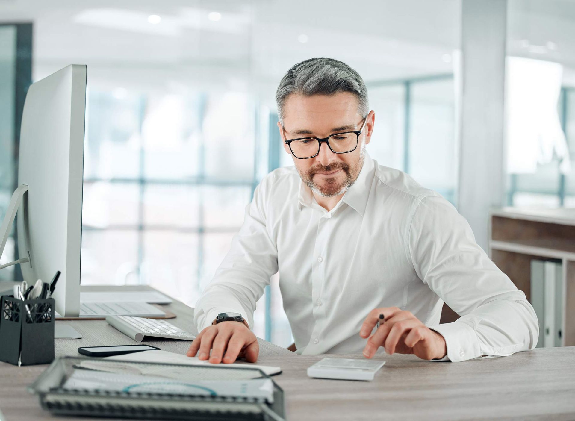 A man is sitting at a desk in front of a computer.