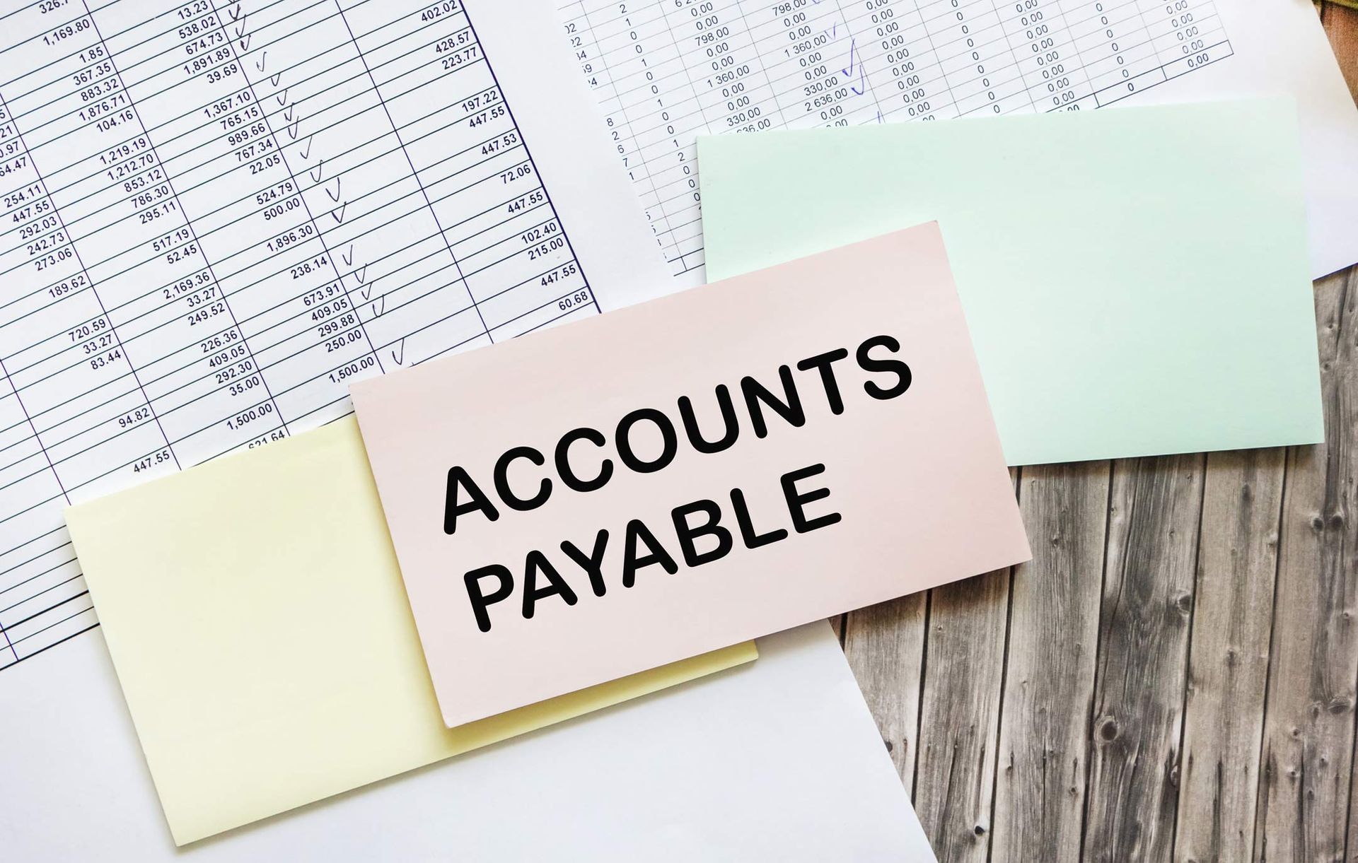 A card that says accounts payable is sitting on top of a pile of papers.