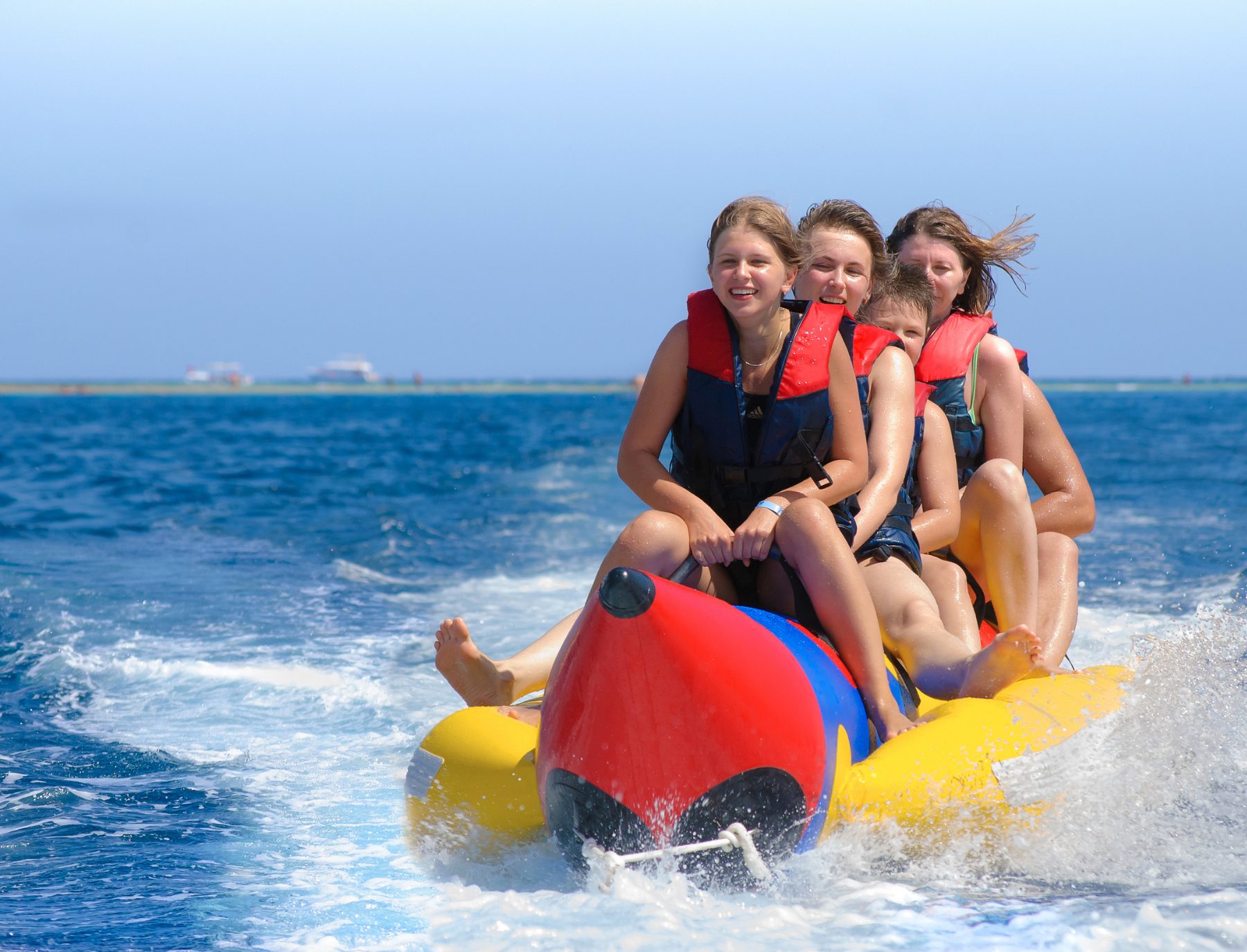 Happy people riding on a single banana boat