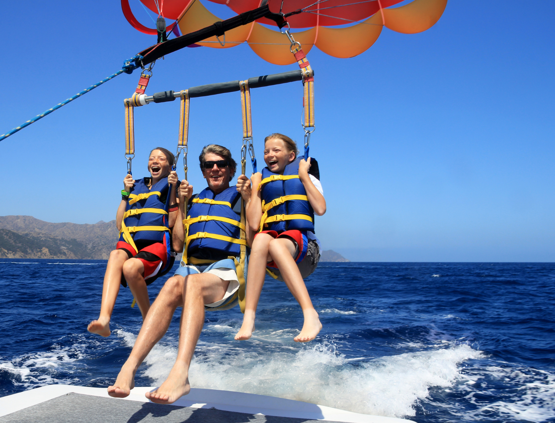 Two girls and one man on parasailing