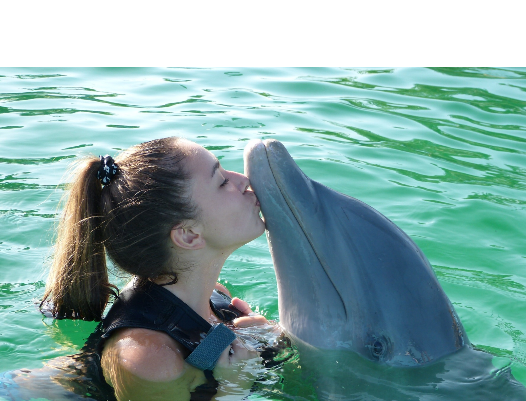 A woman kissing dolphin