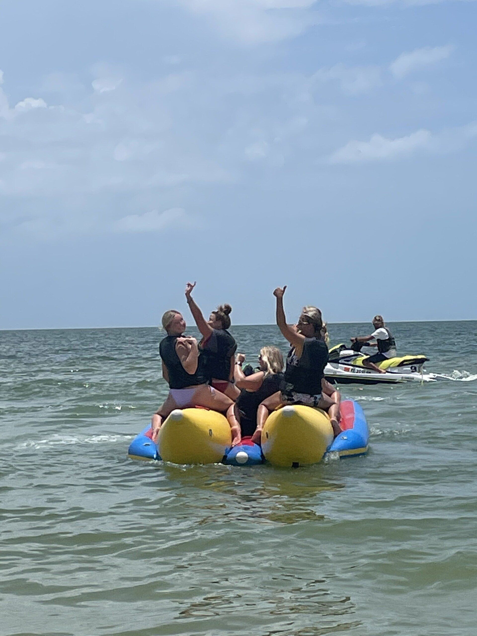 Back view of a people riding on a banana boat