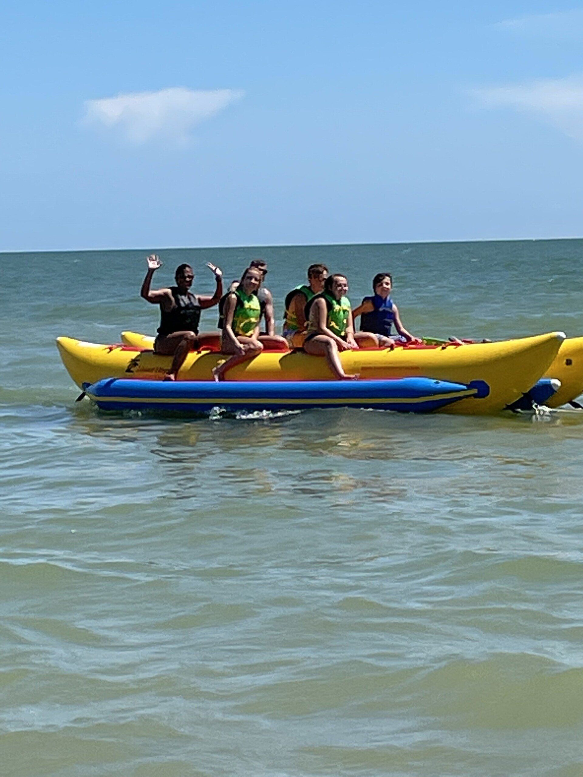 Far and side view of a people riding on a banana boat