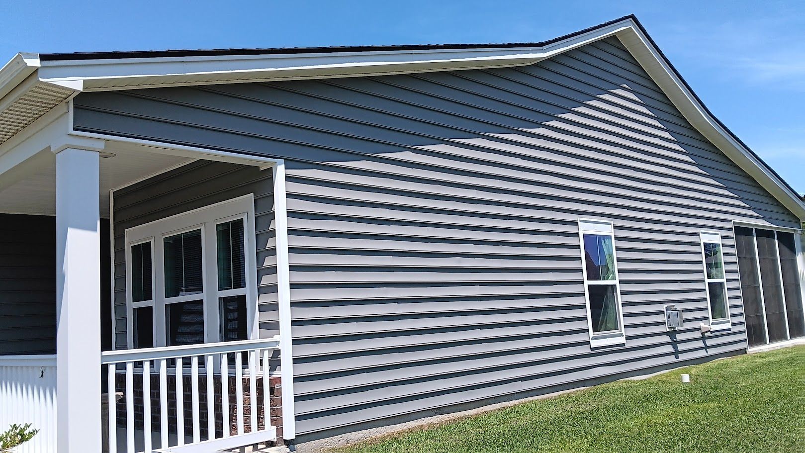 A person is cleaning the roof of a house with a high pressure washer.