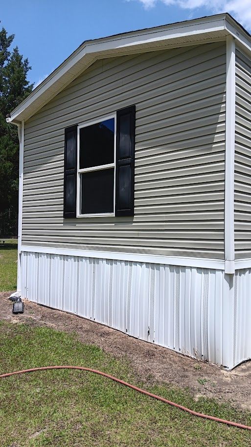 A person is using a high pressure washer to clean a patio.