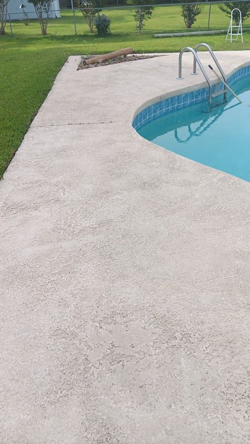 A man is using a high pressure washer to clean a concrete floor.