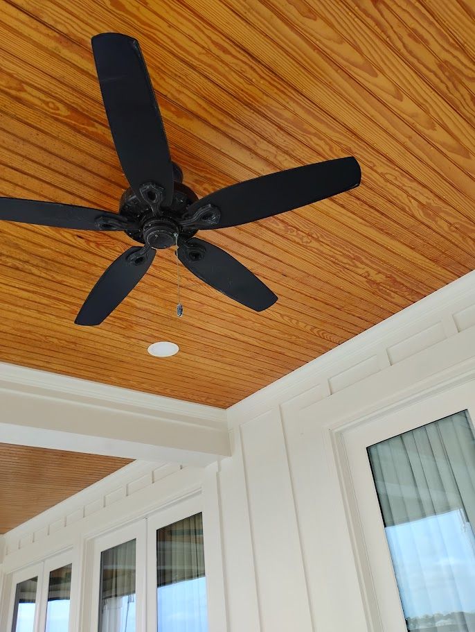 A large white house with a large porch and a red door