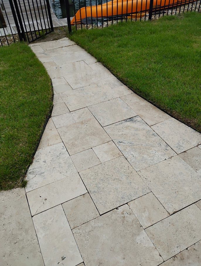 A person is cleaning a siding with a high pressure washer.