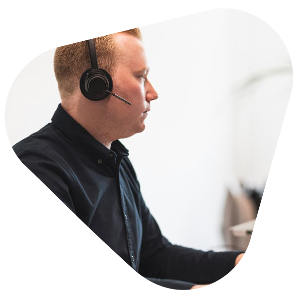 A man with a headset on working in an office.