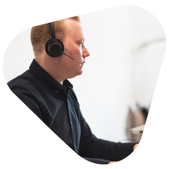 A man with a headset on working in an office.