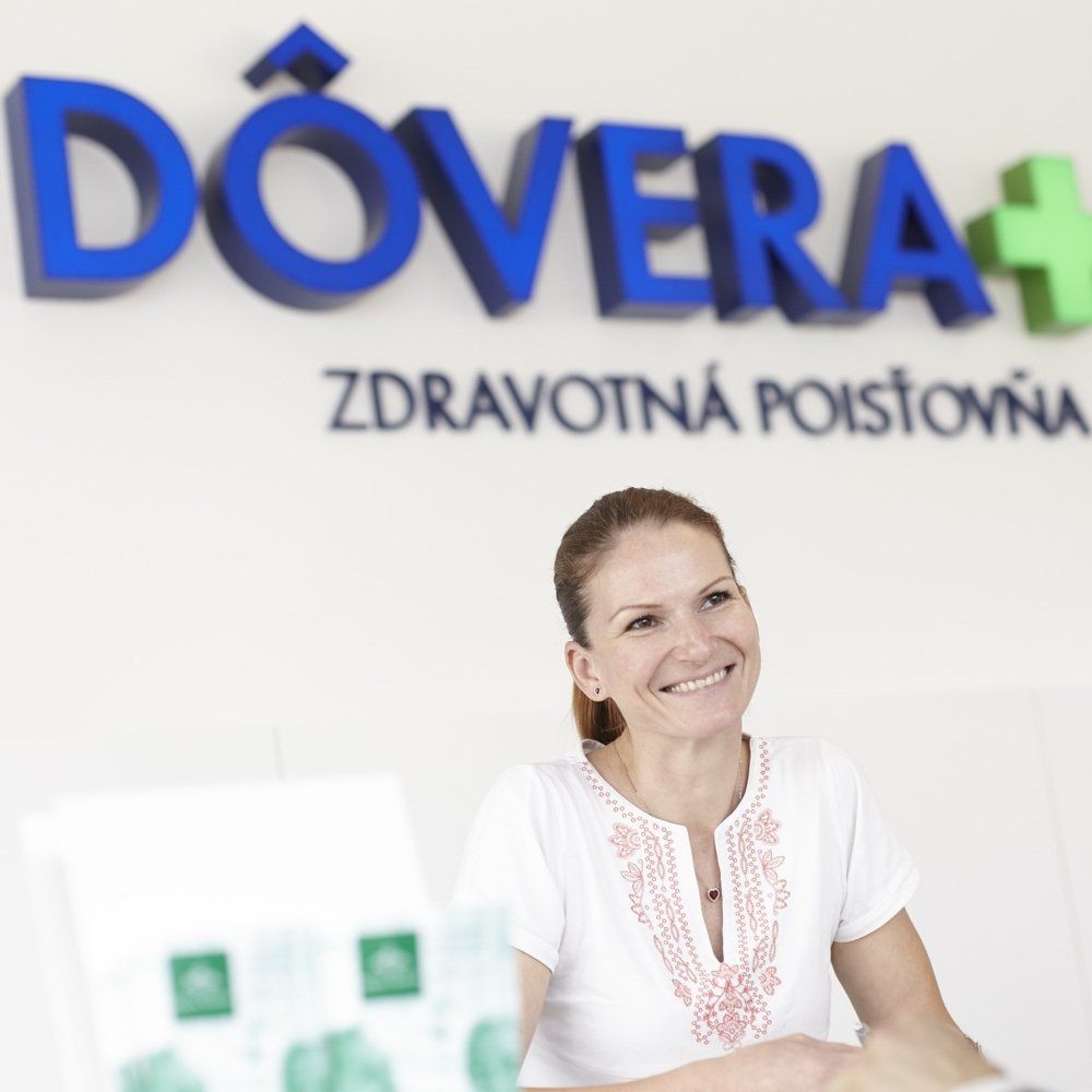 a woman sits in front of a sign that says dovera