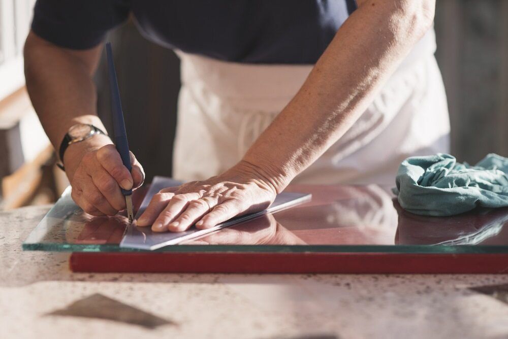 A Person Is Cutting a Piece of Glass with A Pair of Scissors — DecoGlaze in Cardiff, NSW