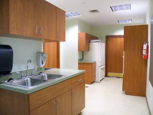 A kitchen with two sinks and a refrigerator