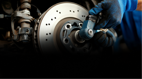 Up close to brakes on vehicle, technician performing repairs | Four Seasons Tire & Auto Service