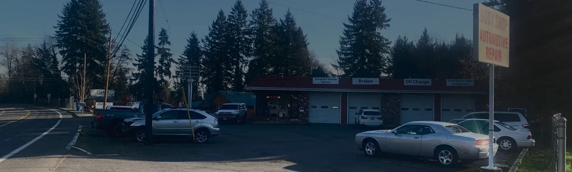 Outside of our shop, picture of our building with cars parked in front in Washington | Four Seasons Tire & Auto Service