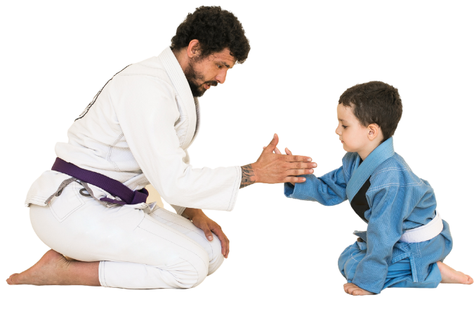 A man in a karate uniform is kneeling down and giving a child a high five