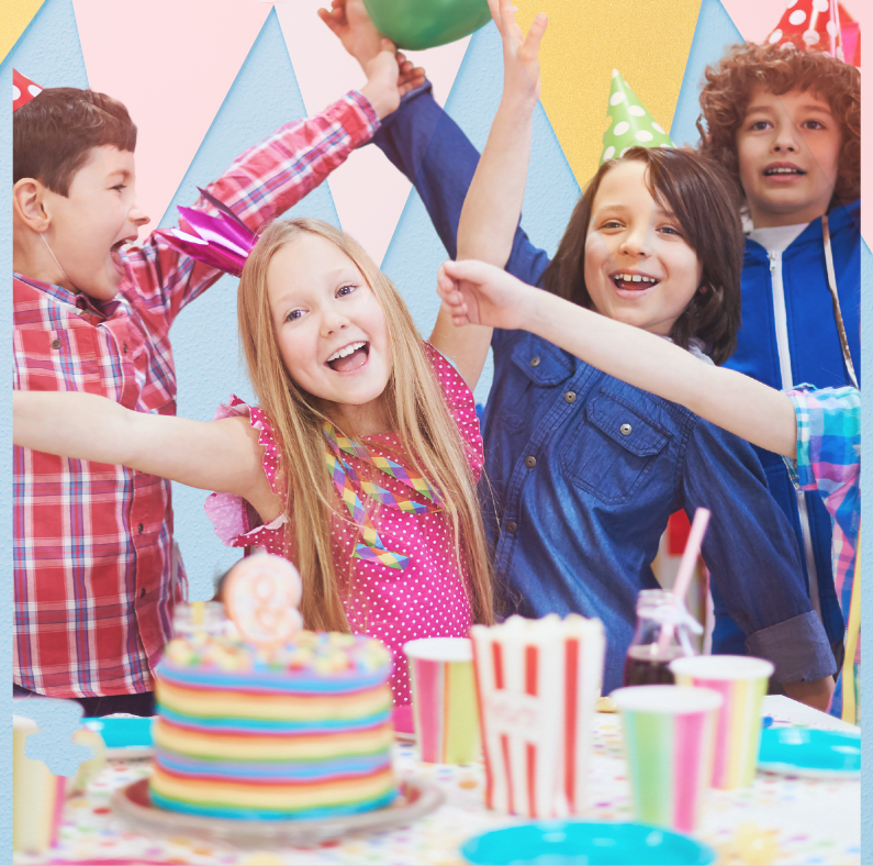 A group of children are celebrating a birthday with their arms in the air