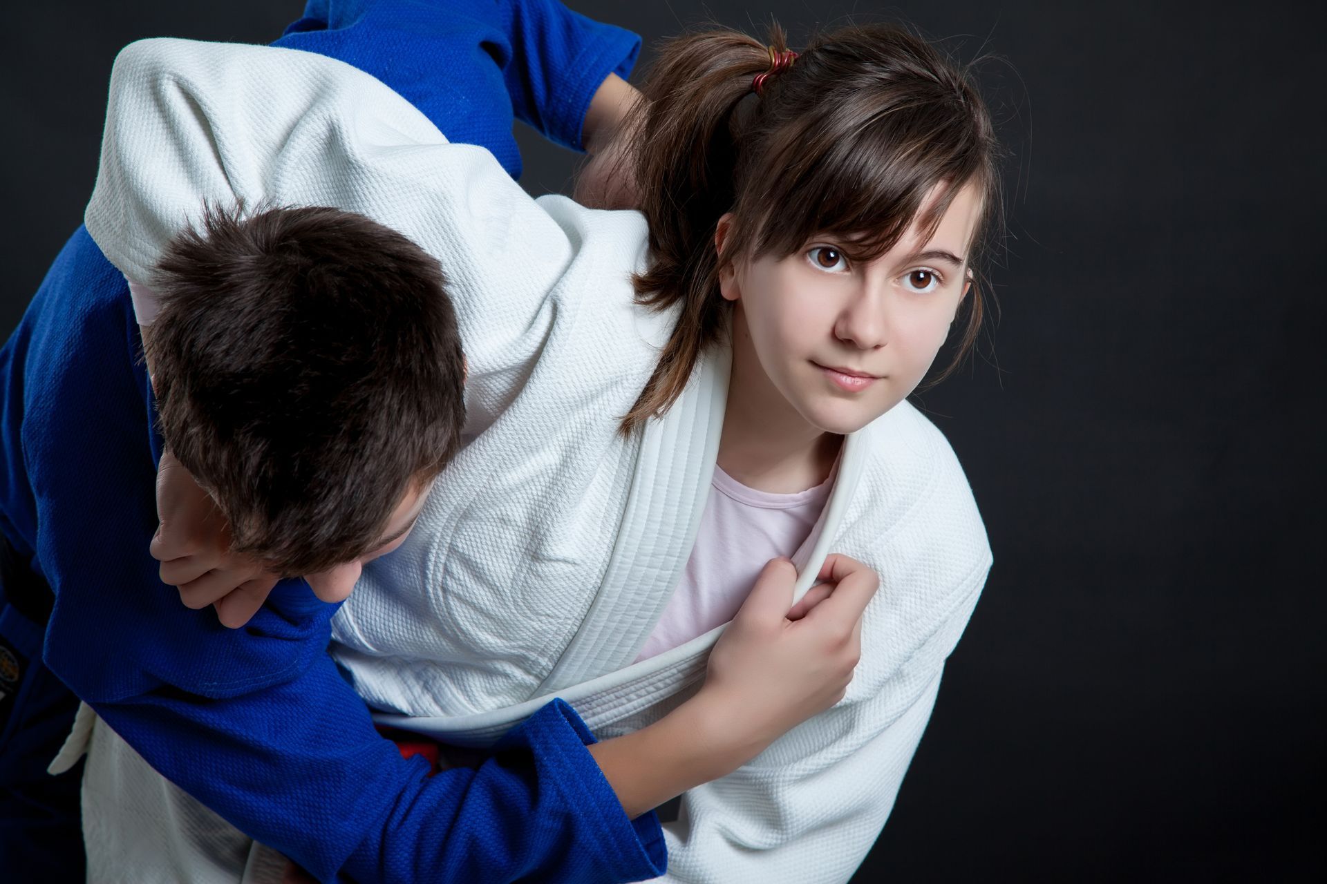 A boy and a girl are practicing judo together.