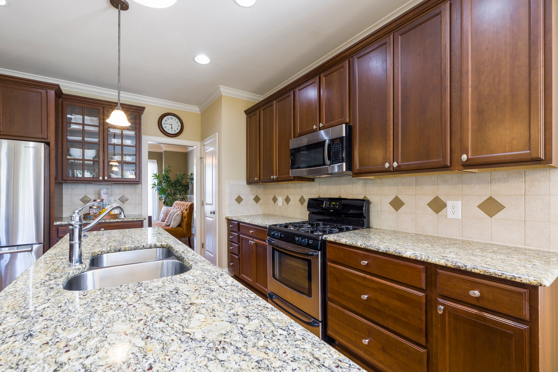 A kitchen with granite counter tops and wooden cabinets.