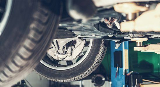 A Car Is Sitting On A Lift In A Garage — Ace-Marian In Marian, QLD