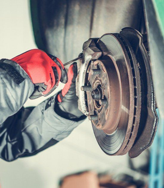 A Person Is Fixing A Brake Disc On A Car — Ace-Marian In Marian, QLD