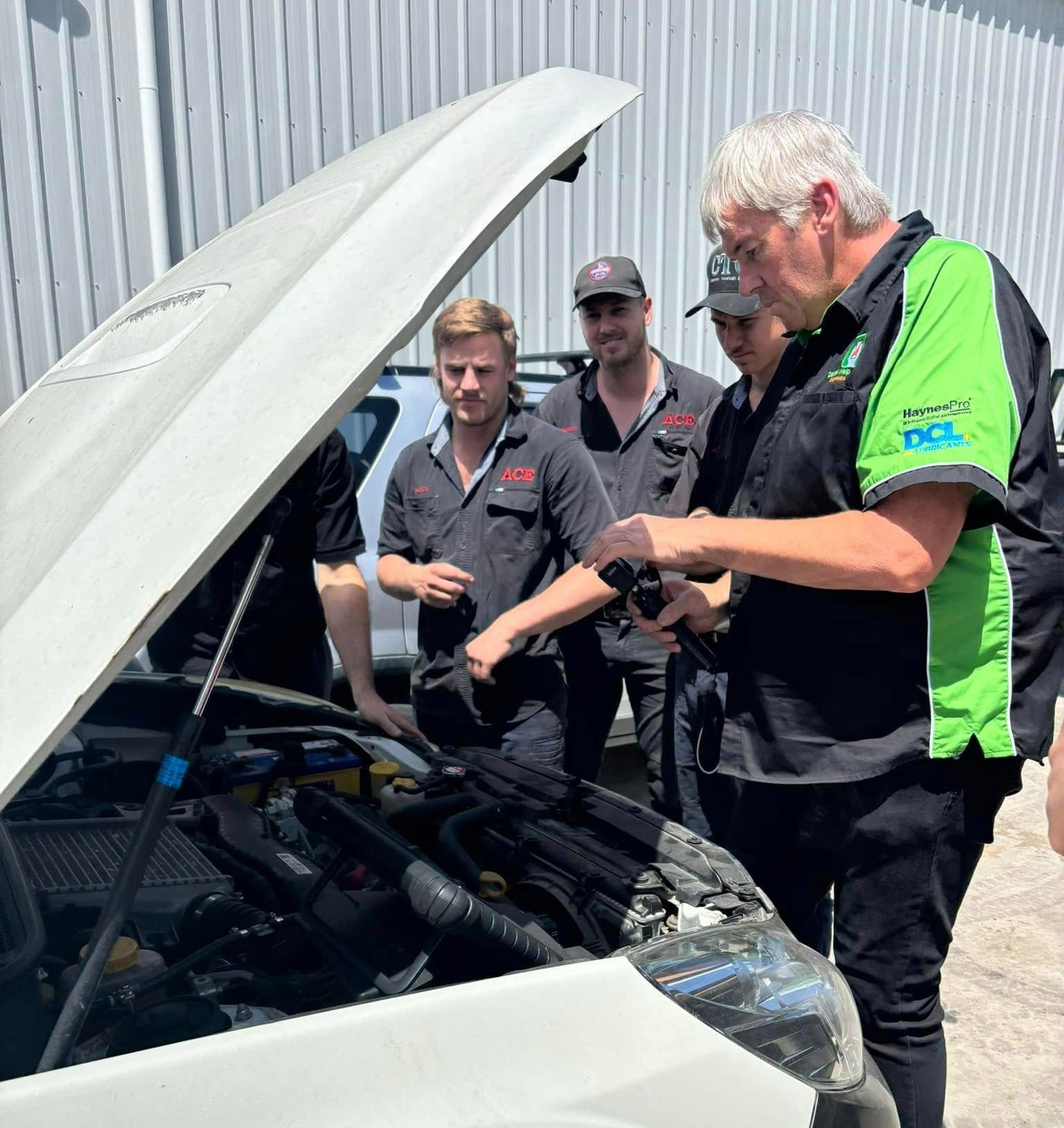 Men Inspecting A White Vehicle