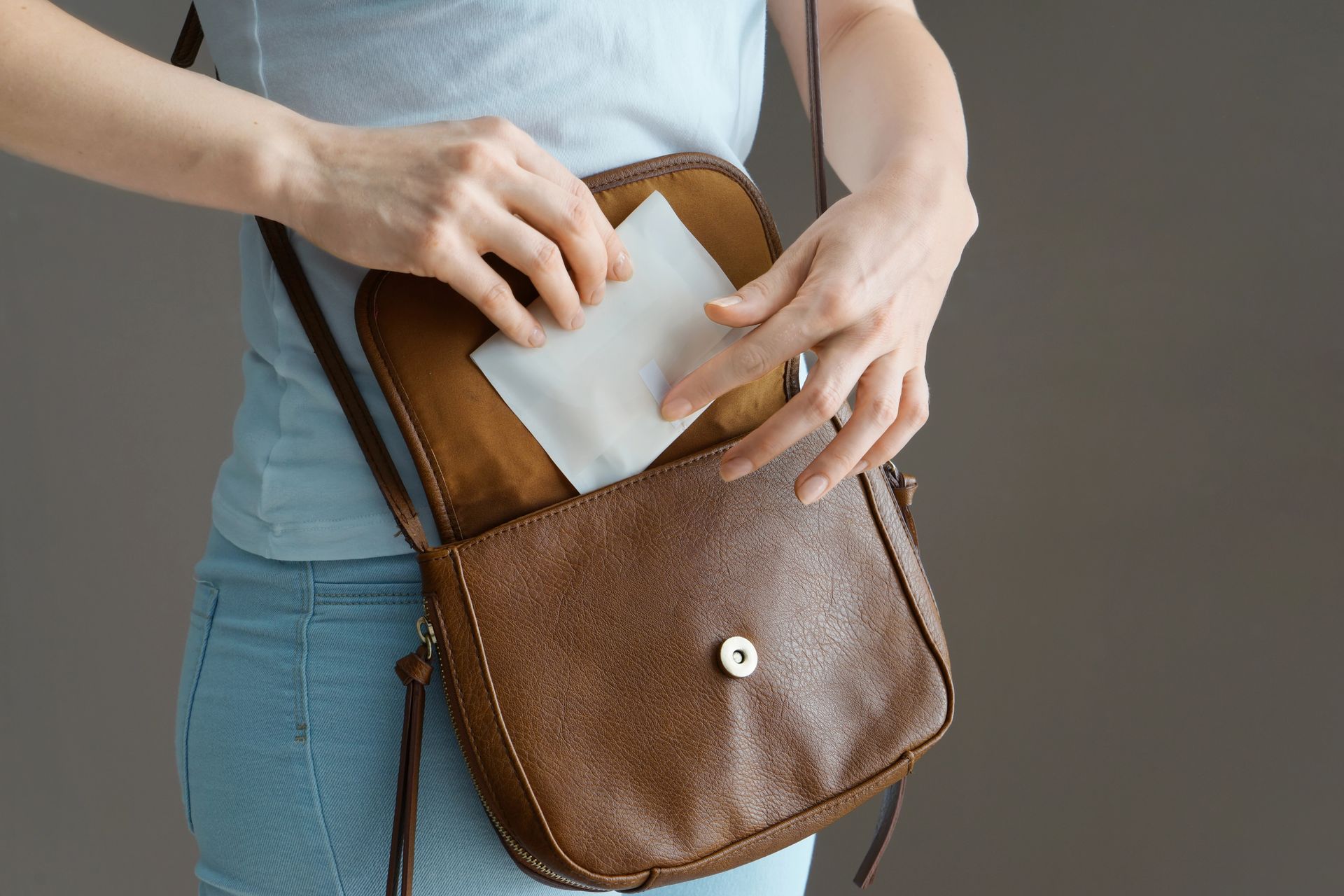 Una mujer saca un trozo de papel de su bolso.