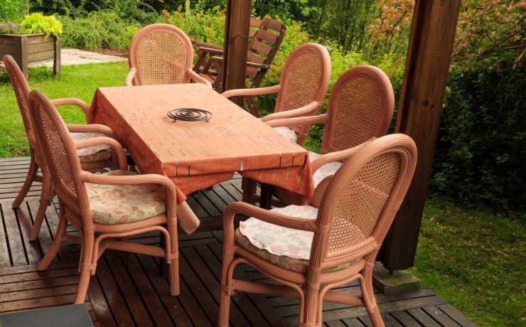 Inviting outdoor wooden deck patio furnished with a rustic dining table and chairs set in a lush Rockford, IL garden setting.