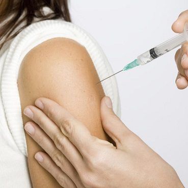 Person receiving an injection in their arm.